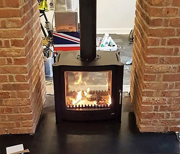 Firebelly FB2 Double Sided Stove - in black with slate hearth.  Installed in Holmbury St. Mary near Dorking, Surrey
